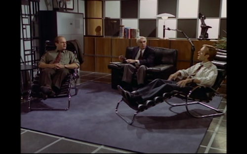 Fraiser, a couples counsellor, and Niles site in a room with leather recliners and a black and white wall. 